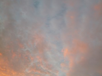 Layer of orange clouds on blue sky