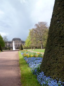 Park with flowerbeds leading to fountain and elegant rococo palace