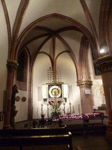 Altar, bright golden, in church, Neo-Gothic, with plenty of lit candles beneath.
