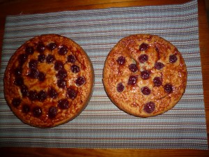 Two round cakes from above, with cherries in patterns.